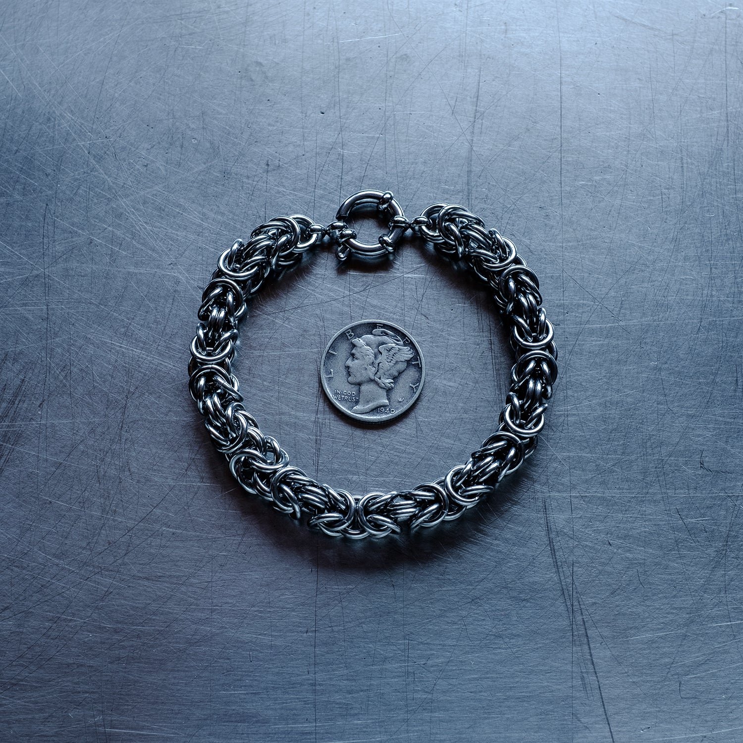 Bold byzantine weave chain Bracelet made of 304 stainless steel on stainless steel surface with a liberty dime for scale