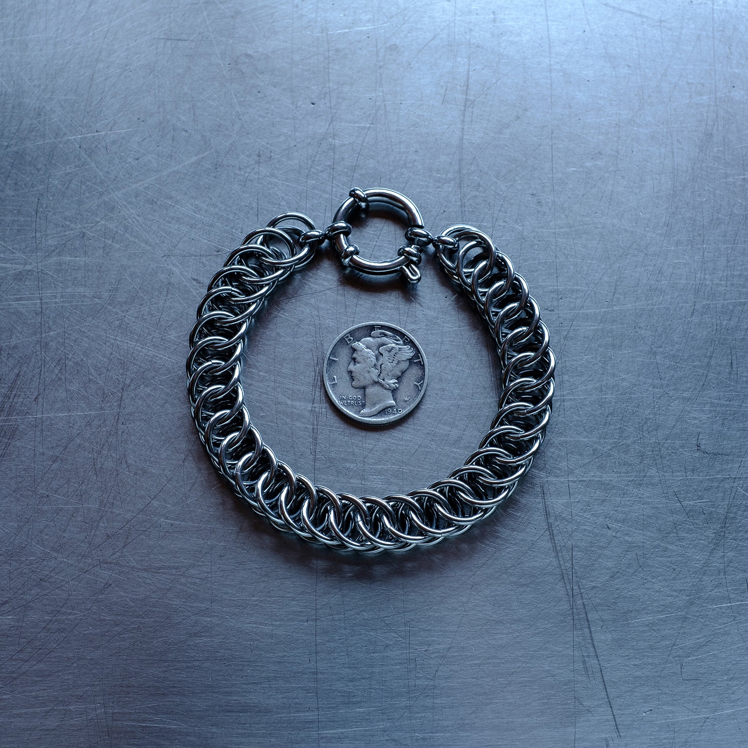 Statement Half Persian weave chain bracelet made with 304 stainless steel on a stainless steel surface with a liberty dime for scale