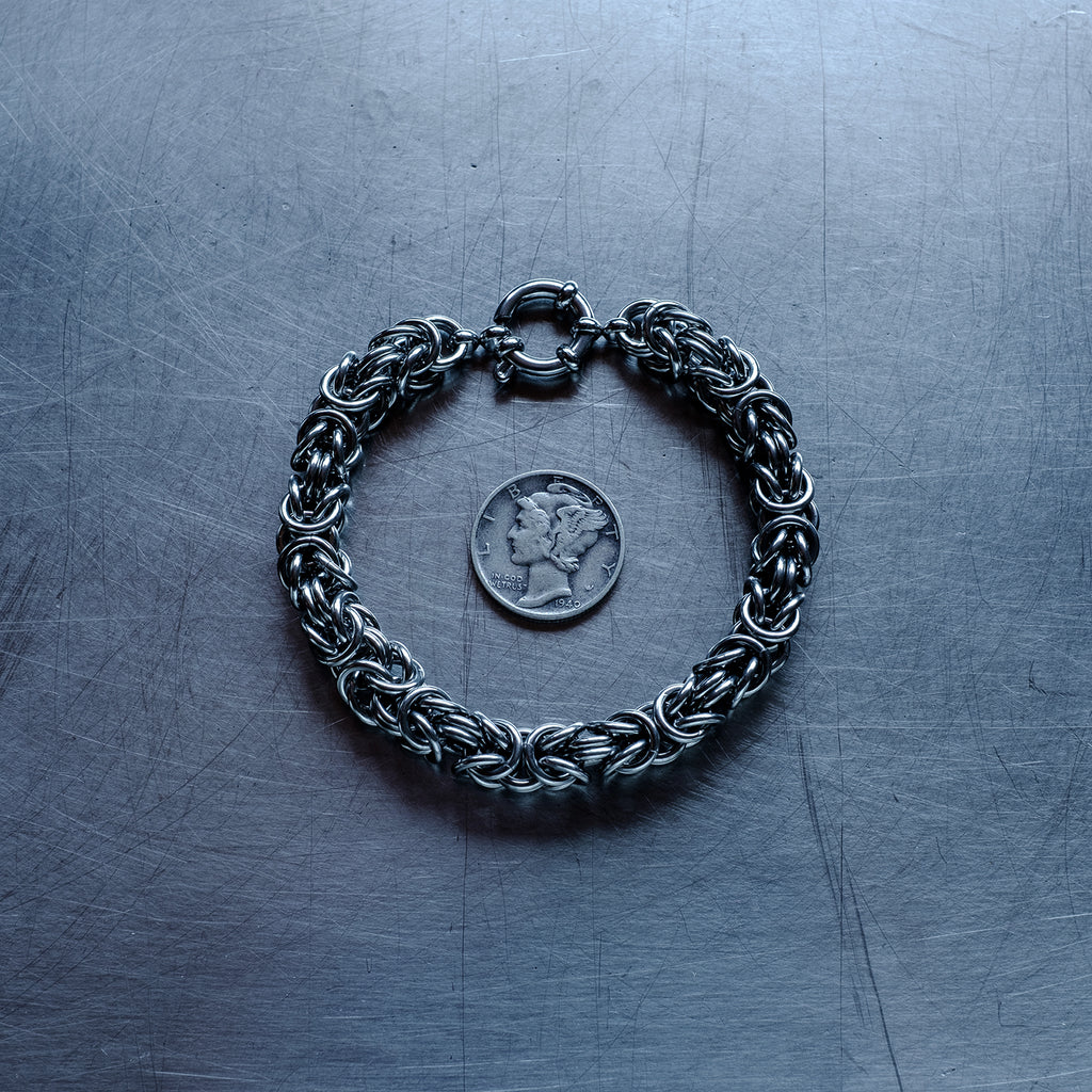 Bold byzantine weave chain Bracelet made of 304 stainless steel on stainless steel surface with a liberty dime for scale