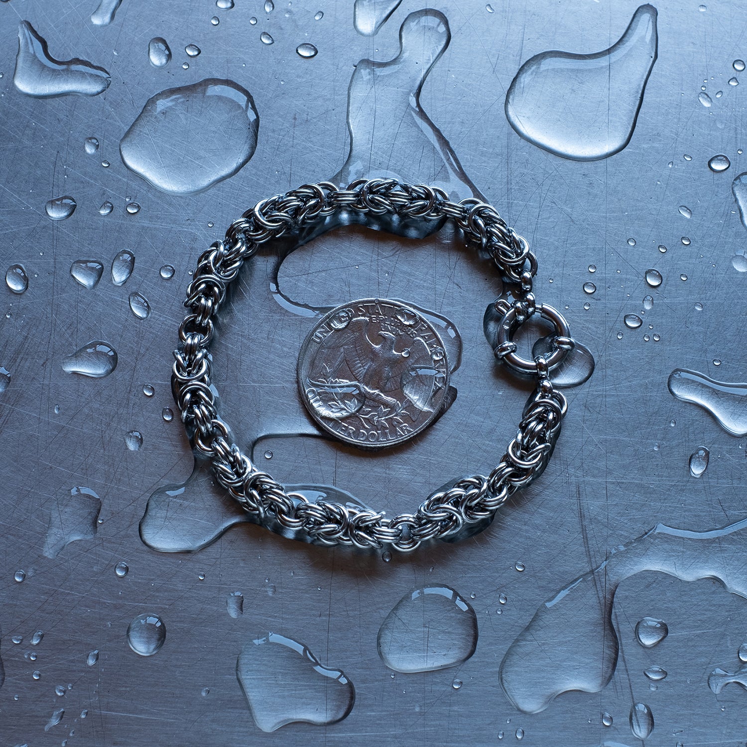 Classic sized Byzantine weave chain bracelet in units configuration made with 304 stainless steel on a wet stainless steel surface with a quarter for scale