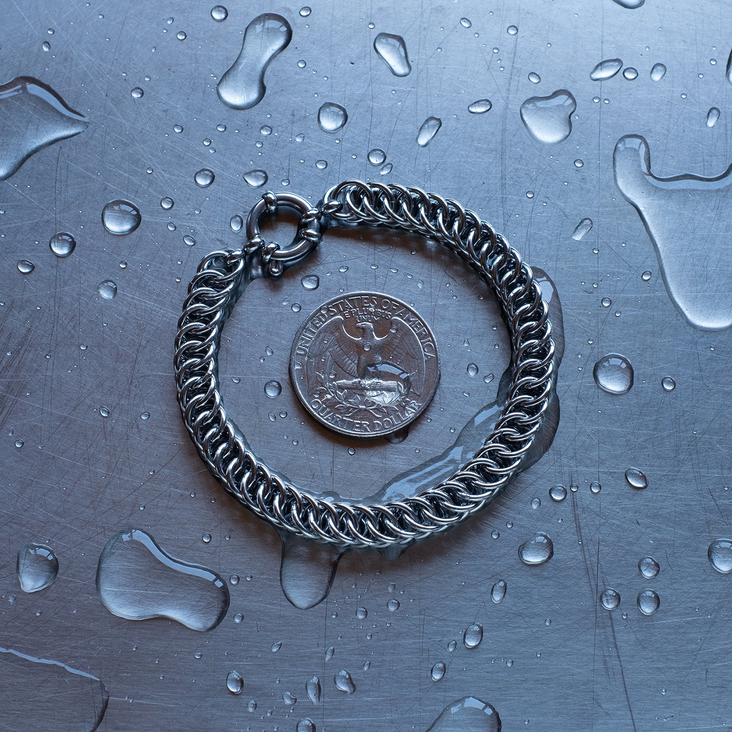 Classic in size, Half persian weave chain bracelet made with 304 stainless steel on a wet stainless steel surface with a quarter for scale