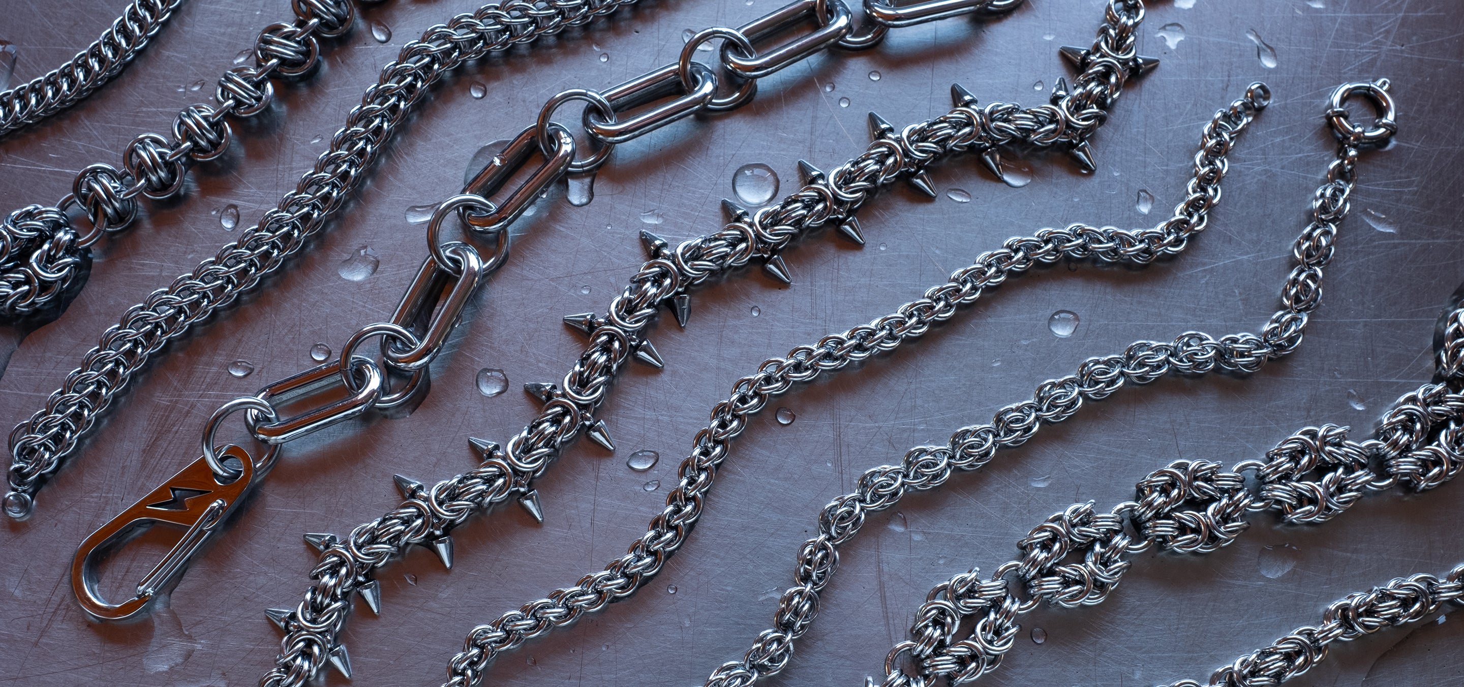 304 Stainless steel chainmaille bracelets organized in an aesthetic way on a wet stainless steel surface