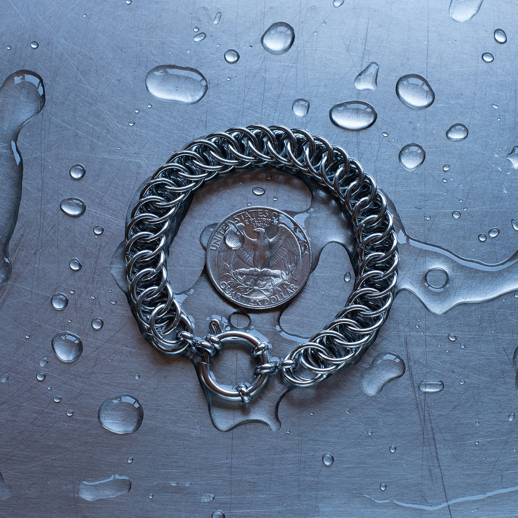 Statement Half Persian weave chain bracelet made with 304 stainless steel on a wet stainless steel surface with a quarter for scale