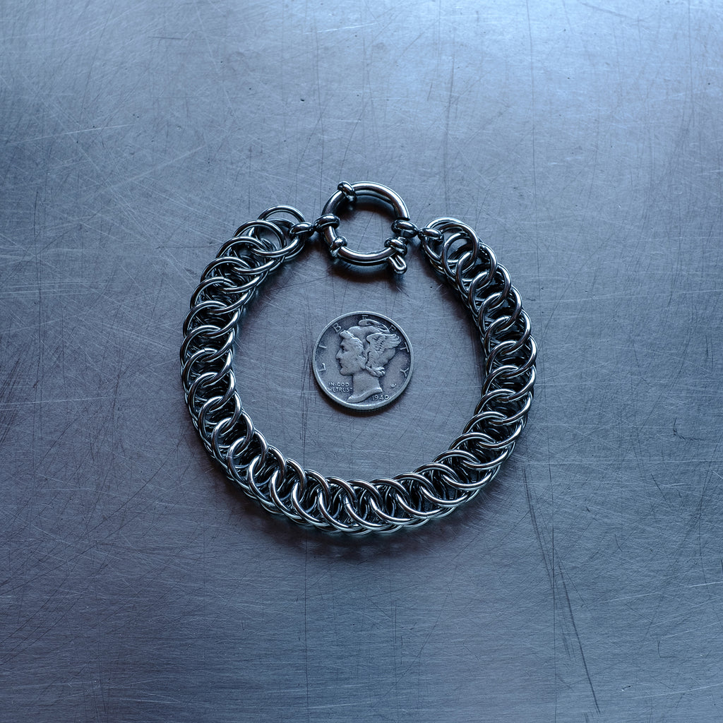 Statement Half Persian weave chain bracelet made with 304 stainless steel on a stainless steel surface with a liberty dime for scale